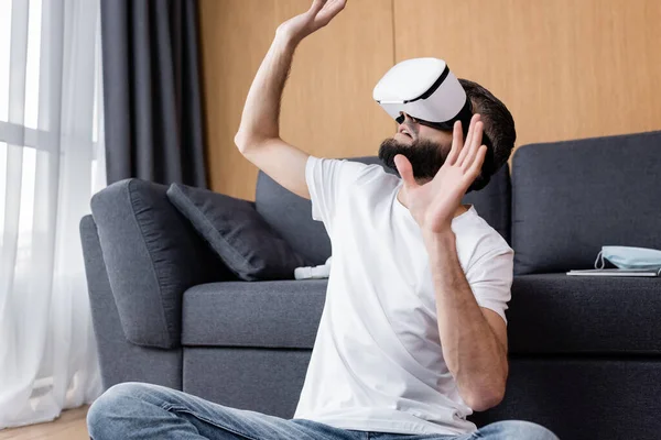 Hombre en auriculares vr jugando videojuego en el suelo en la sala de estar - foto de stock