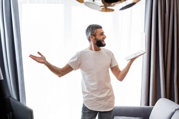 Freelance sorridente che fa videochiamata su computer portatile a casa — Foto stock