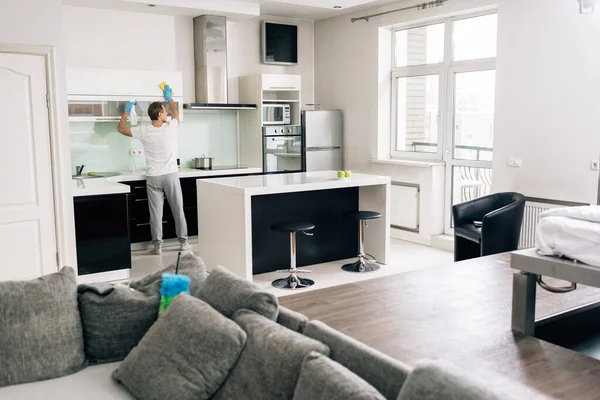 Enfoque selectivo de la cocina de limpieza del hombre en el hogar moderno - foto de stock