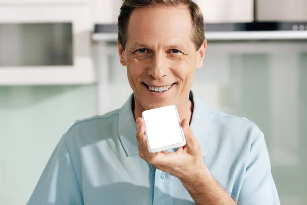 Homme heureux tenant smartphone avec écran blanc tout en enregistrant un message vocal — Photo de stock