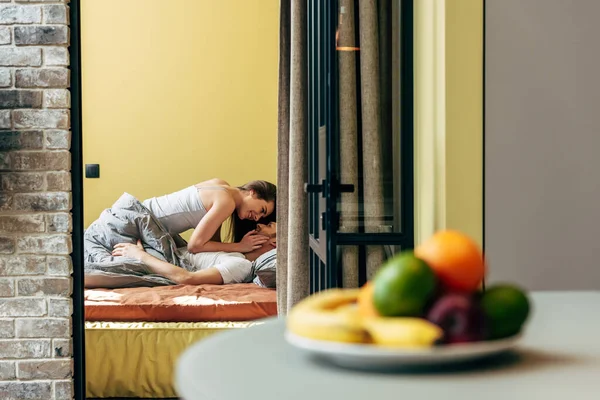 Foco seletivo de homem feliz e mulher olhando um para o outro no quarto — Fotografia de Stock