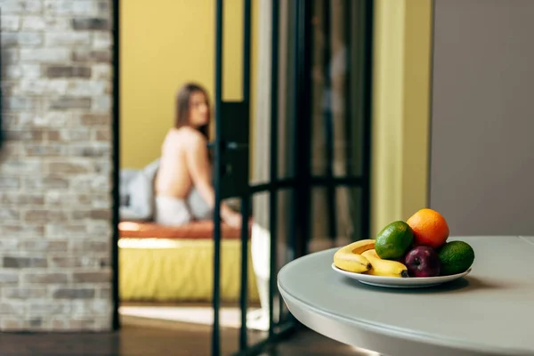 Selective focus of tasty fruits near woman in bedroom — Stock Photo