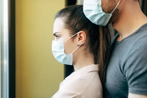 Foco seletivo da mulher e do homem em máscaras médicas — Fotografia de Stock