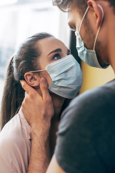 Foco seletivo do homem tocando menina em máscara médica em casa — Fotografia de Stock