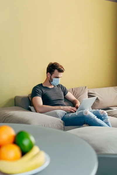 Selective focus of freelancer in medical mask working from home — Stock Photo