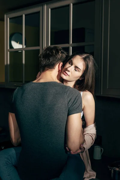 Back view of man kissing attractive woman with closed eyes — Stock Photo