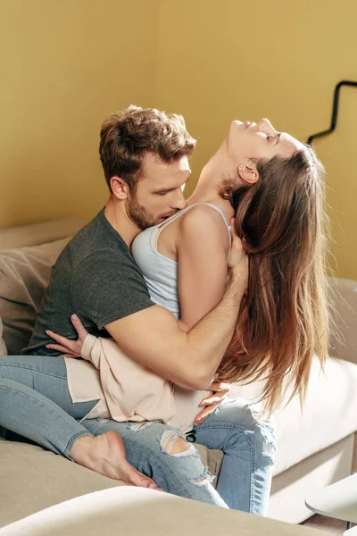 Страстный мужчина целует красивую девушку в гостиной — стоковое фото