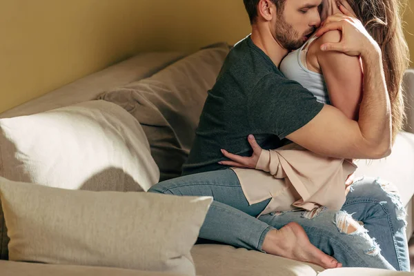 Passionate man kissing seductive girl in living room — Stock Photo