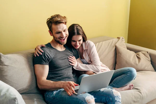 Couple joyeux regarder le film et rire près de l'ordinateur portable — Photo de stock