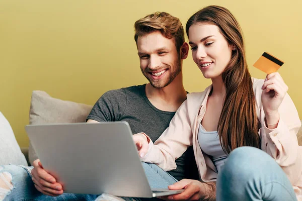 Homem feliz compras on-line perto da menina com cartão de crédito e laptop — Fotografia de Stock