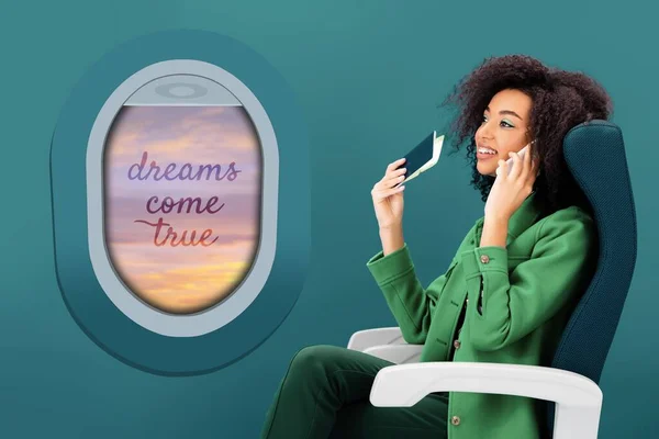 Femme afro-américaine souriante parlant sur smartphone et tenant un passeport avec billet d'avion sur fond vert avec hublot — Photo de stock