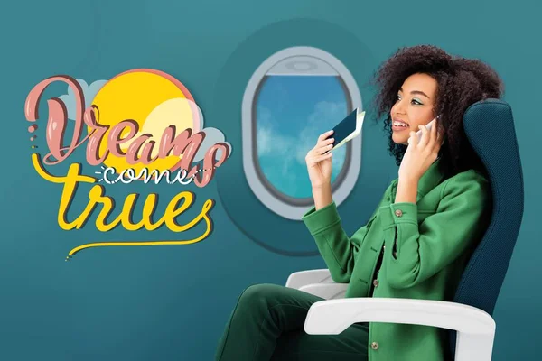 Sonriente mujer afroamericana hablando en smartphone y sosteniendo pasaporte con billete de avión sobre fondo verde con ojo de buey - foto de stock