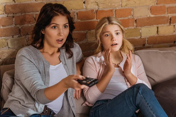 Selective focus of excited mother and daughter watching movie at home — Stock Photo