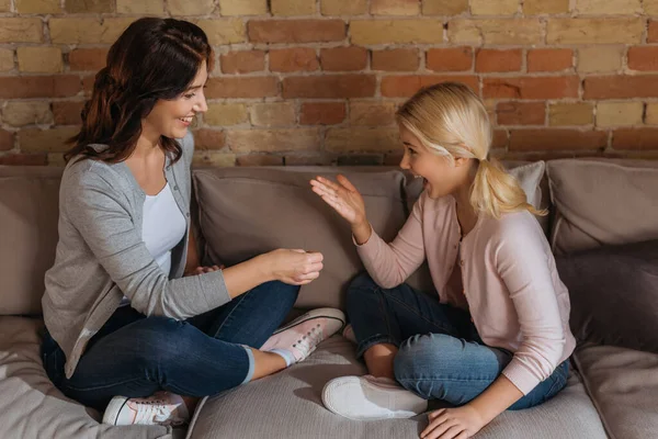 Side view of cheerful kid playing rock paper scissors with mother at home — Stock Photo