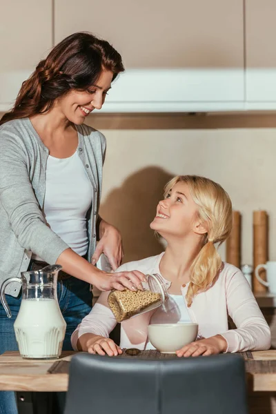 Selektiver Fokus von Kind und Mutter, die sich beim Frühstück in der Küche anlächeln — Stockfoto