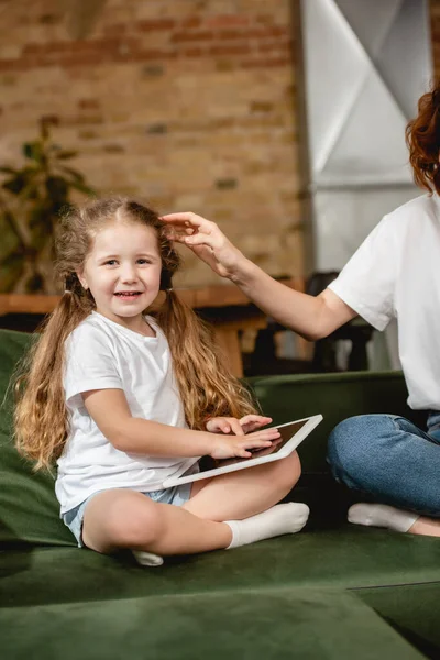 Mother touching cute daughter with digital tablet — Stock Photo