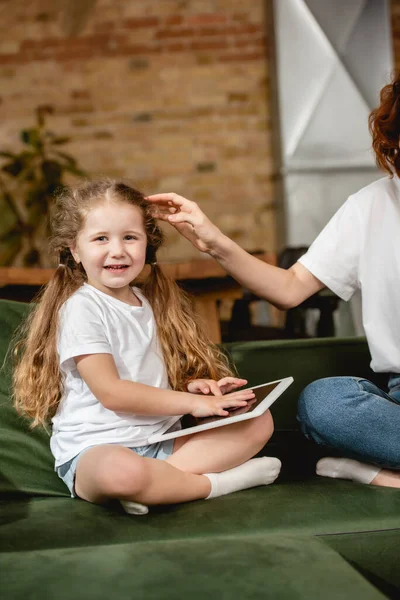 Madre toccando carina figlia con tablet digitale — Foto stock