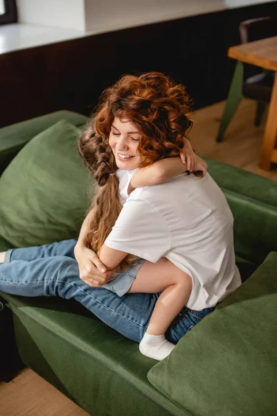 Cute daughter hugging happy and curly mother — Stock Photo