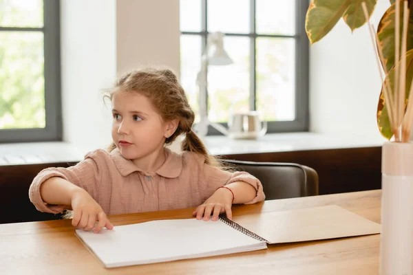 Entzückendes Kind, das in der Nähe von leerem Papier wegschaut — Stockfoto