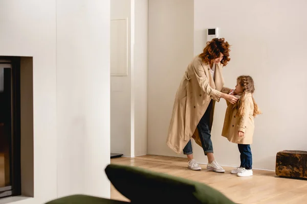 Foyer sélectif de mère touchant trench coat sur fille — Photo de stock