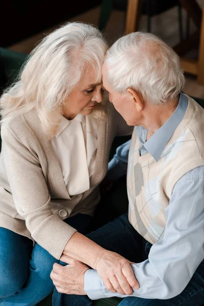 Upset senior wife and husband hugging and sitting at home on quarantine — Stock Photo