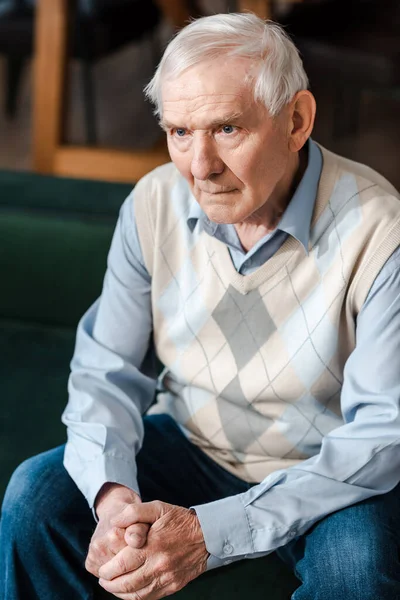 Lonely senior man sitting on sofa during self isolation — Stock Photo