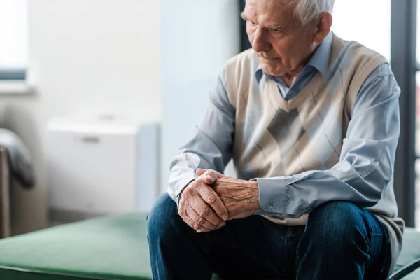 Trauriger älterer Mann sitzt während Selbstisolierung allein auf Sofa — Stockfoto