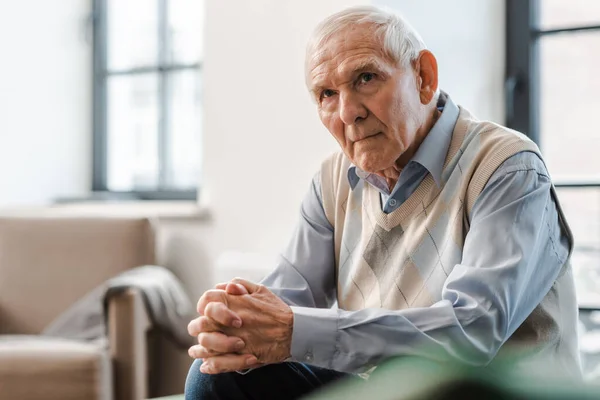 Triste homme âgé assis seul sur le canapé pendant la quarantaine — Photo de stock