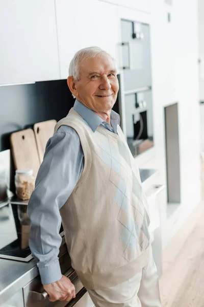 Souriant vieil homme sur la cuisine pendant la quarantaine — Photo de stock