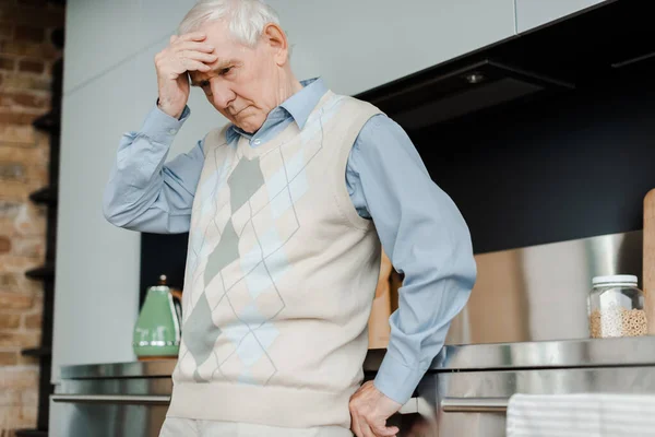 Tired elderly man with headache standing at home during self isolation — Stock Photo