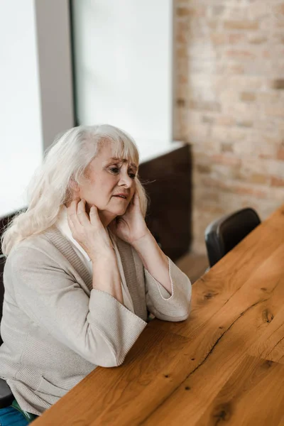 Tired elderly woman sitting at home during self isolation — Stock Photo