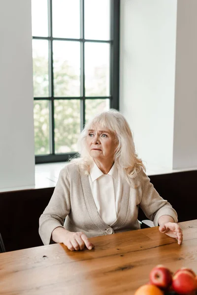 Triste anciana sentada en casa durante el autoaislamiento - foto de stock