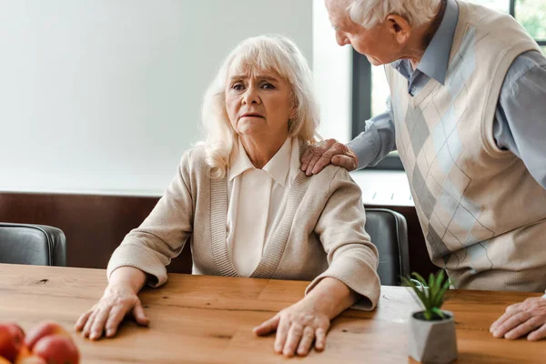 Worried elderly couple sitting at home on self isolation — Stock Photo