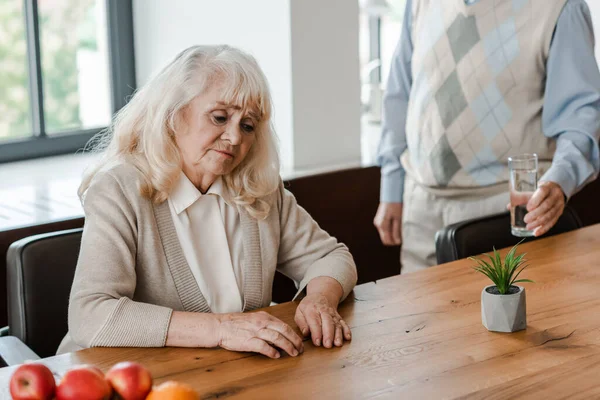 Älterer Mann und kranke Frau mit Glas Wasser zu Hause während der Quarantäne — Stockfoto