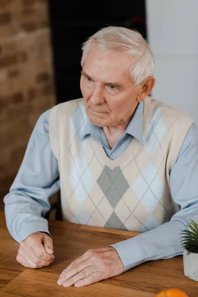 Bouleversé homme âgé assis à la maison pendant la quarantaine — Photo de stock