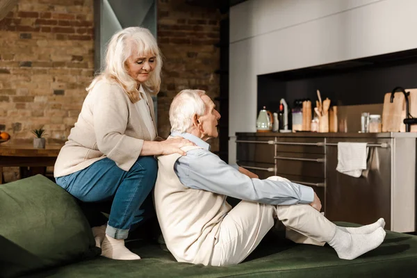 Positivo casal de idosos fazendo massagem e refrigeração em casa em quarentena — Fotografia de Stock