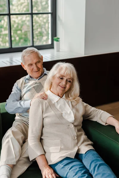 Feliz pareja de ancianos haciendo masaje y descansando en casa en auto aislamiento - foto de stock