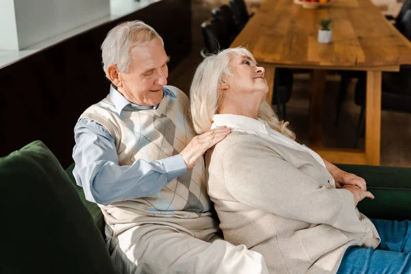 Счастливая пожилая пара делает массаж и расслабляется дома на самоизоляции — стоковое фото