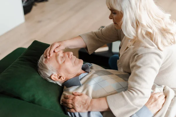 Besorgte ältere Frau überprüft Temperatur ihres Mannes zu Hause auf Selbstisolierung — Stockfoto