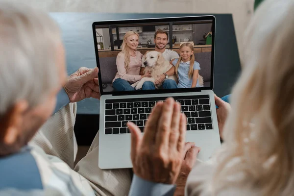 Abuelos saludando mientras tienen video chat con la familia en cuarentena - foto de stock