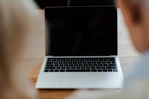 Cropped view of senior couple having video chat on laptop with blank screen at home during quarantine — Stock Photo