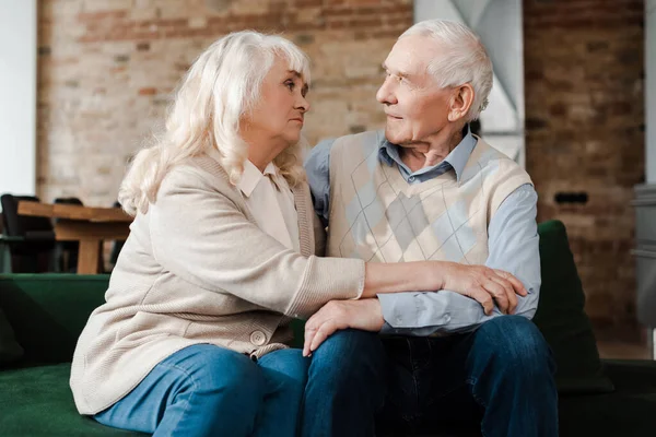 Upset elderly couple sitting at home on quarantine — Stock Photo