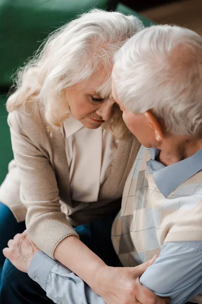 Triste pareja de ancianos abrazándose en casa en cuarentena - foto de stock