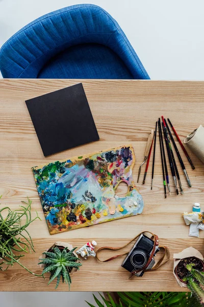 Groene planten met art supplies op tafel — Stockfoto