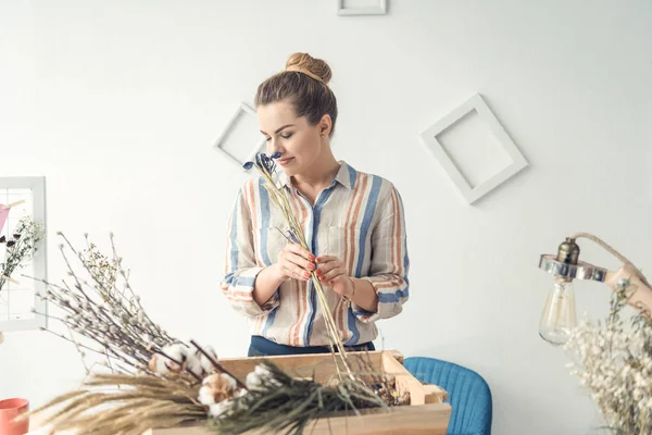 Florista com flores no local de trabalho — Fotografia de Stock