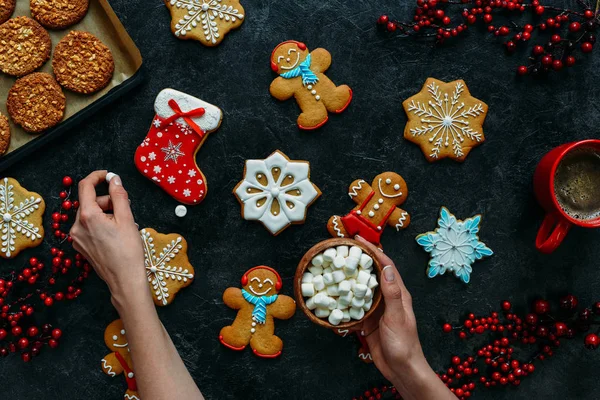 Kerst gingerbreads en marshmallows in handen — Stockfoto