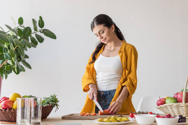 smiling woman cutting carrot