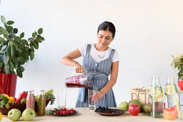 Woman pouring detox drink into glass — Stock Photo, Image