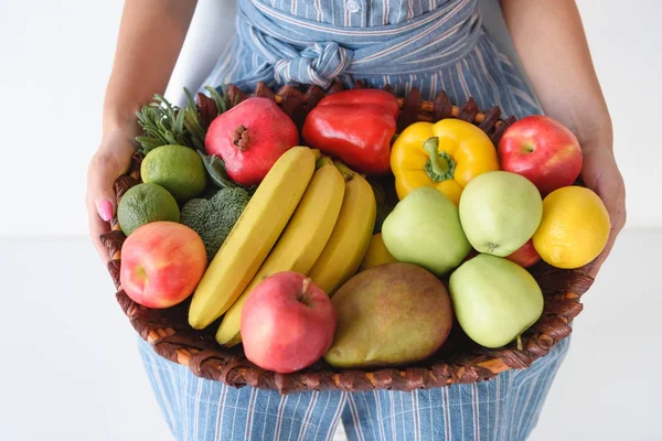 Woman holding basket with harvest — Stock Photo, Image