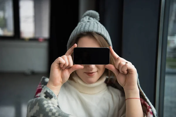 Woman covering eyes with smartphone — Free Stock Photo